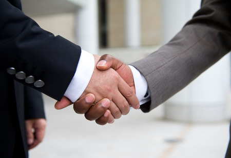 African businessman's hand shaking white businessman's hand  making a business deal.の写真素材