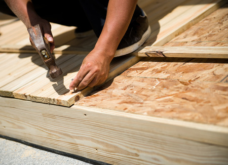 Man laying laminate flooring with tools.の写真素材