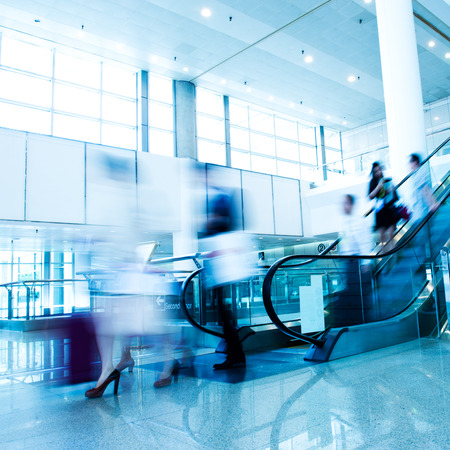Group of businesspeople moving down on escalator in office. blurred motion.のeditorial素材