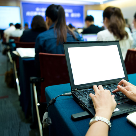 Business people typing on laptop keyboard at conference.の写真素材