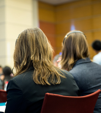 Rear view of business people listening attentively at conference.の写真素材