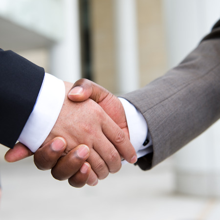 African businessman's hand shaking white businessman's hand  making a business deal.の写真素材