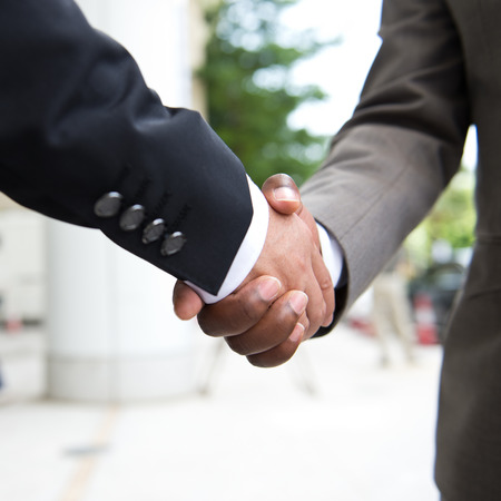 African businessman's hand shaking white businessman's hand  making a business deal.の写真素材