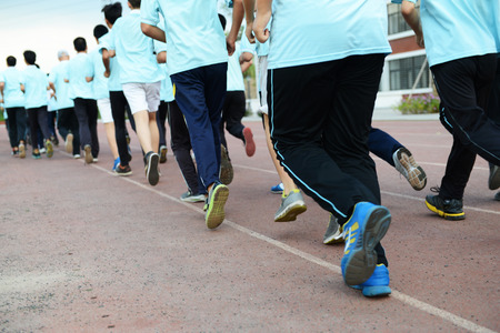 Group of students running on a racing track.の写真素材