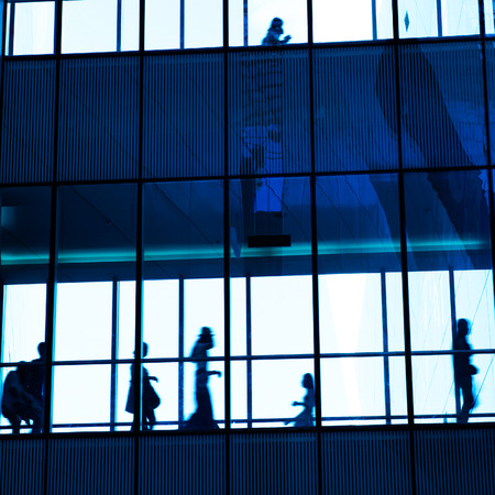 silhouettes of business people rushing at morden office building.のeditorial素材