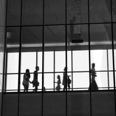 silhouettes of business people rushing at morden office building.のeditorial素材