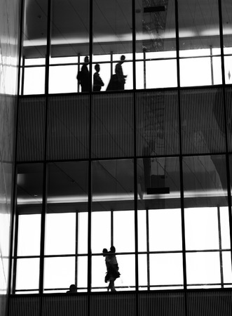 silhouettes of business people rushing at morden office building.のeditorial素材