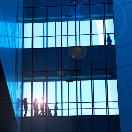 silhouettes of business people rushing at morden office building.のeditorial素材