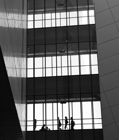 silhouettes of business people rushing at morden office building.のeditorial素材