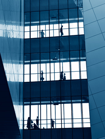 silhouettes of business people rushing at morden office building.のeditorial素材