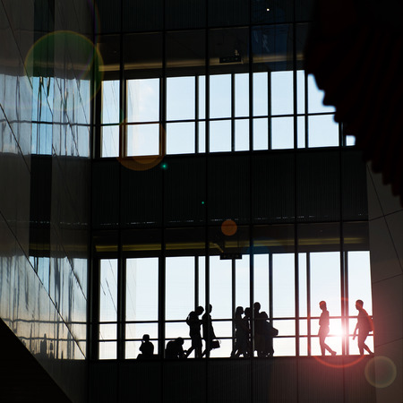 silhouettes of business people rushing at morden office building.のeditorial素材