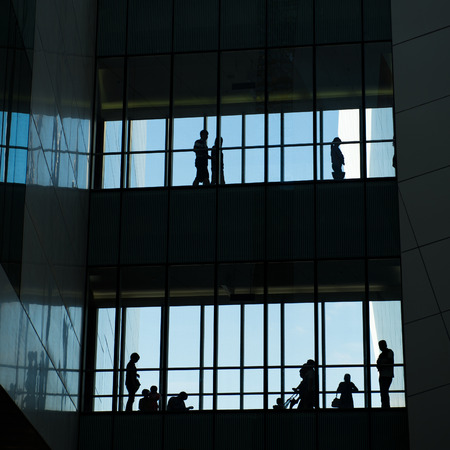 silhouettes of business people rushing at morden office building.のeditorial素材