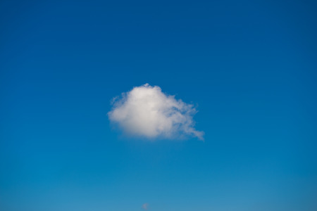 single white cloud against the blue sky.の写真素材