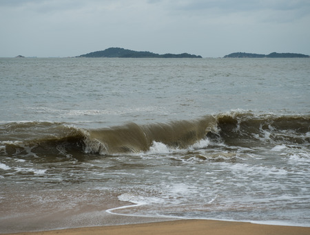 Waves breaking on the shore of the sea with foamの写真素材