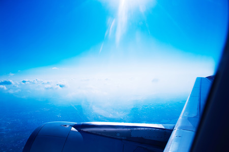 Airplane at fly on the sky, view through aircraft window.の写真素材