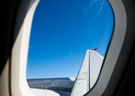 Airplane at fly on the sky, view through aircraft window.の写真素材