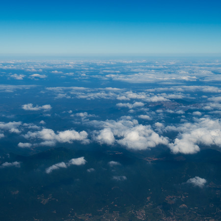 Blue sky with white clouds, view from a flying airplane.の写真素材