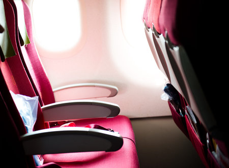 empty airplane interior with  red seats and window.の写真素材
