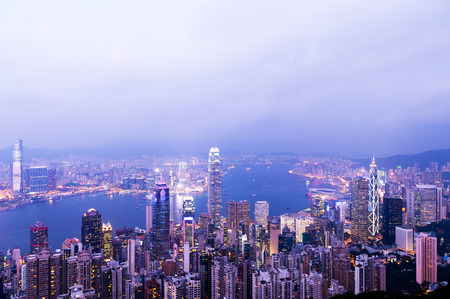 Hong Kong cityscape at night with victoria harbour and large group of tall buildings.の写真素材