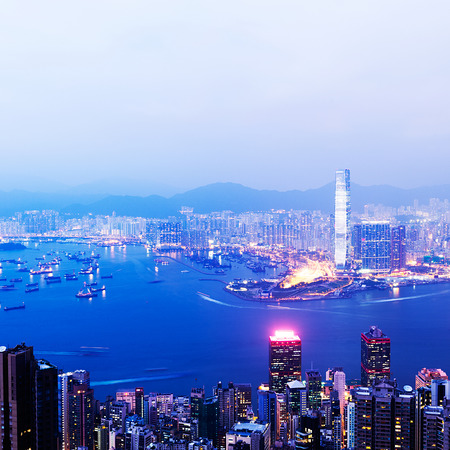 Hong Kong cityscape at night with victoria harbour and large group of tall buildings.の写真素材