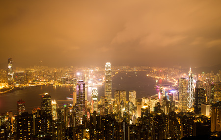 Hong Kong cityscape at night with victoria harbour and large group of tall buildings.の写真素材