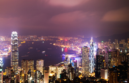 Hong Kong cityscape at night with victoria harbour and large group of tall buildings.の写真素材
