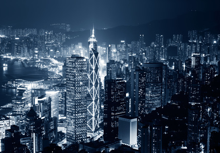 Hong Kong cityscape at night with victoria harbour and large group of tall buildings.の写真素材