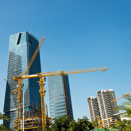 Construction site with cranes on blue sky background.の写真素材