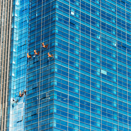 Workers of steeplejack washing windows of the modern building.の写真素材