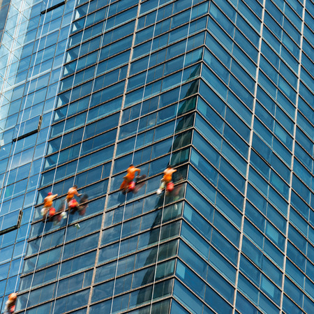 Workers of steeplejack washing windows of the modern building.の写真素材