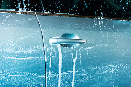 Car wash with flowing water and foam.の写真素材