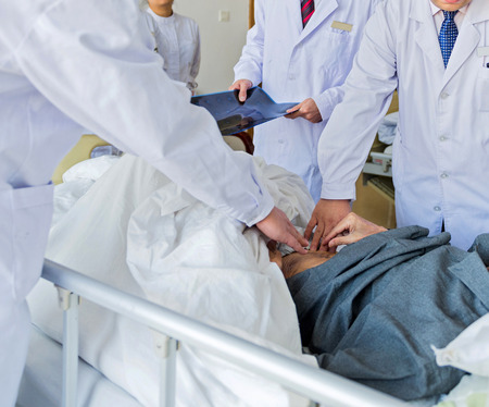Medical team examining patient in hospital.の写真素材