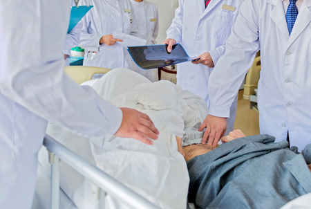 Medical team examining patient in hospital.の写真素材