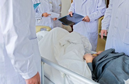 Medical team examining patient in hospital.の写真素材