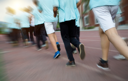 Group of students running on a racing track.の写真素材