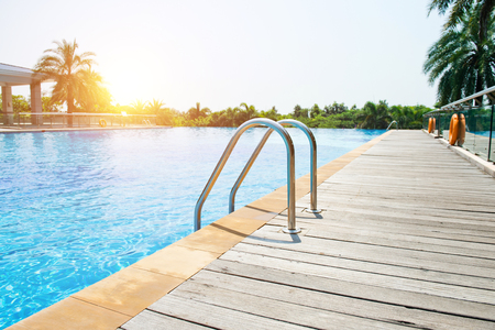 Swimming pool with stair and wooden deck at hotel.のeditorial素材