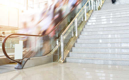 Group of businesspeople moving down on escalator in office. blurred motion.のeditorial素材