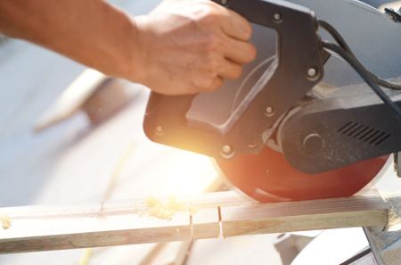 Carpenter cutting wood by electric saw.の写真素材