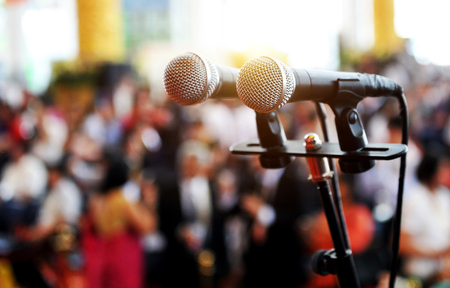 Closeup microphone in auditorium with people.の写真素材