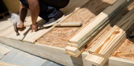 Man laying laminate flooring with tools.の写真素材