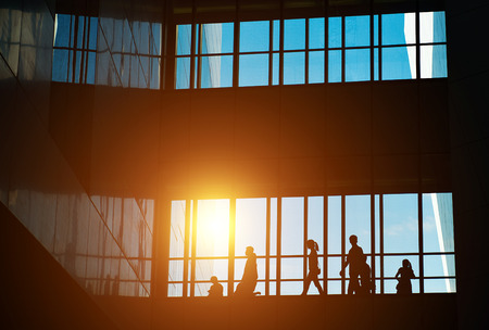 silhouettes of business people rushing at morden office building.のeditorial素材