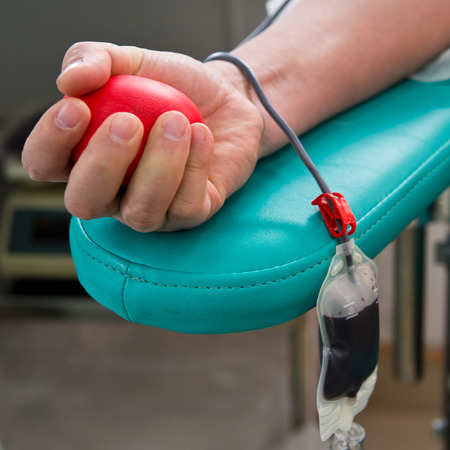 Blood donor at donation with a bouncy ball holding in hand.の写真素材