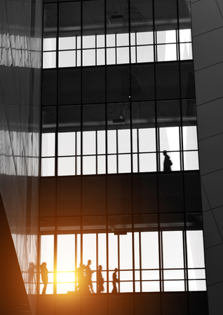 silhouettes of business people rushing at morden office building.のeditorial素材