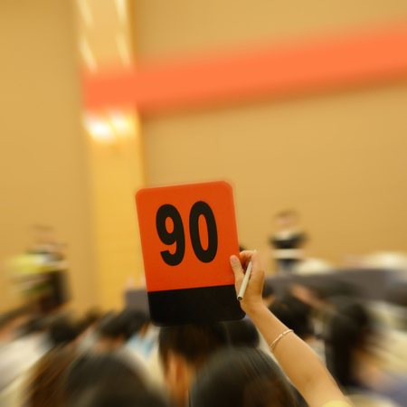People holding auction paddle to buy from auction.の写真素材