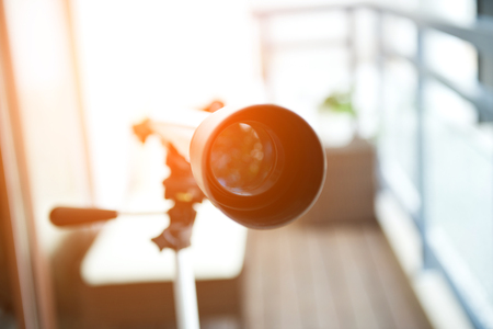 A telescope setting near the window.の写真素材
