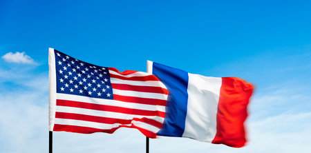 USA and France flags against blue sky backgroundの写真素材