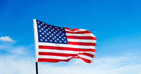 American flag waving on blue sky backgroundの写真素材