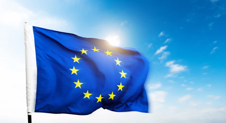 European Union flag waving against blue sky backgroundの写真素材