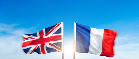 France and Britain flags against blue sky backgroundの写真素材
