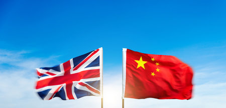 China and Britain flags against blue sky backgroundの写真素材